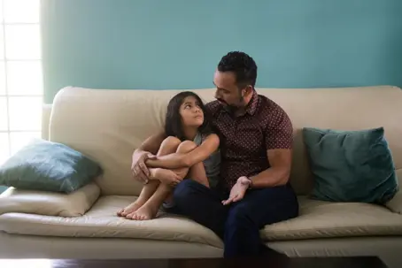 father and daughter talking and embracing