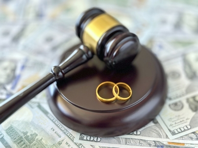 wedding rings and gavel on top of money