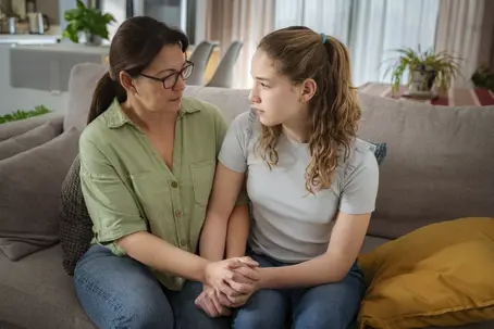 mother comforting teen daughter